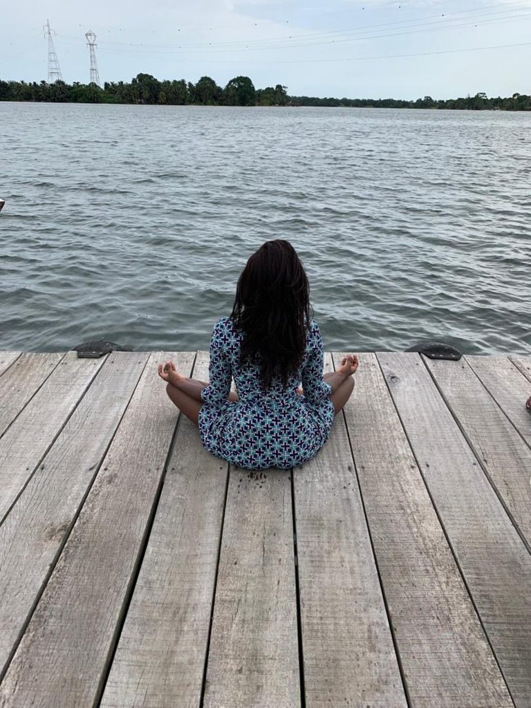 Woman meditating by water. Meditation is an important way to build inner strength and essential tool for growth